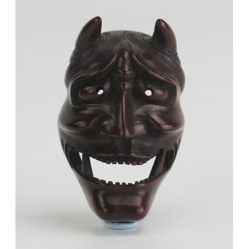 156 - A Japanese carved boxwood netsuke of a noh theatre Hannya mask, signed Doraku, 4.5cm high. Meiji per... 