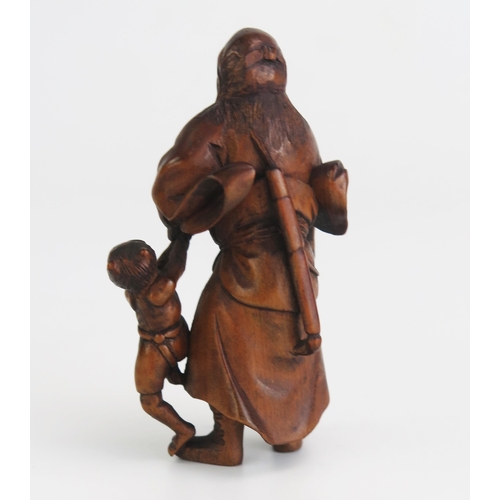 157 - A Japanese carved okimono of Shoki the demon queller, the standing figure with oni in one hand and a... 