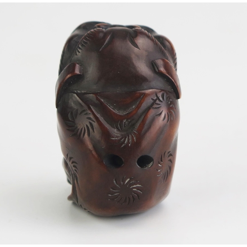 160 - A Japanese carved hardwood netsuke depicting a man putting on a Dragons head costume, unsigned, 5cm ... 