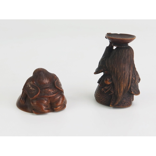 161 - A Japanese carved boxwood netsuke depicting a man holding on to an upturned dish, unsigned, 4cm long... 