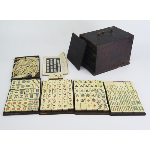 165 - An early 20th century Mah Jong set with bone and bamboo backed tiles, gaming counters, instructions,... 