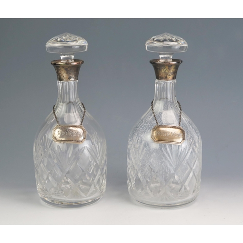 167 - A pair of clear glass and silver mounted decanters of mallet form, with silver collars and palmette ... 