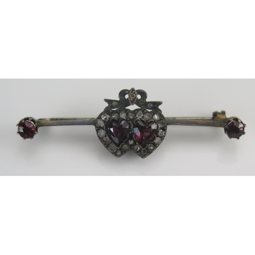 20 - An Antique Garnet and Diamond Chip Conjoined Heart Brooch in a precious yellow metal setting, 5.7mm ... 