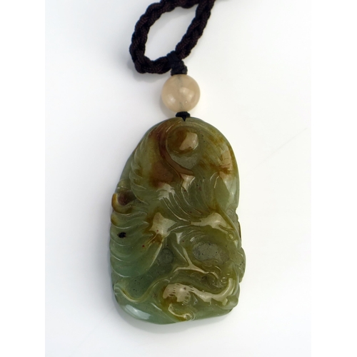 210 - A Chinese carved jade pendant, of oval form one side carved with a phoenix bird, the reverse decorat... 