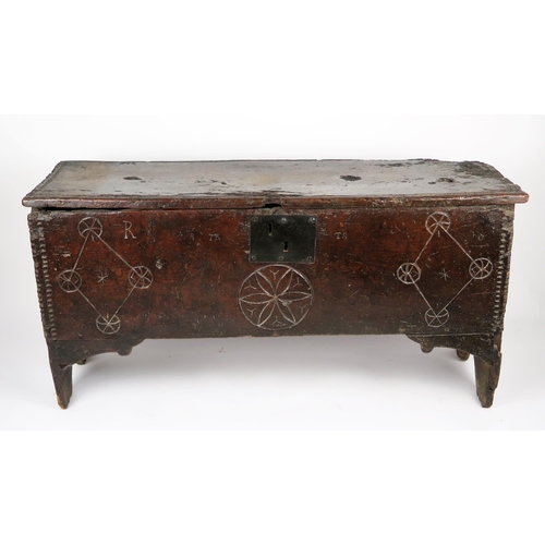 346 - A 17th century elm coffer, of rectangular outline, the hinged lid with moulded and chip carved edge,... 