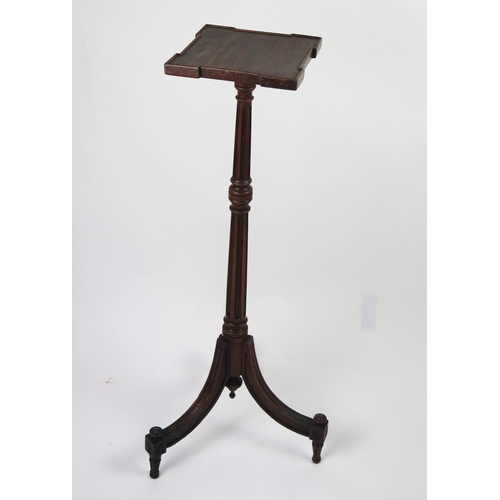 351 - An Edwardian mahogany torchiere stand with square top raised on a fluted and knopped column and swep... 