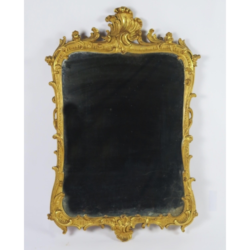 361 - A carved gilt wood wall mirror, the rectangular mirror plate enclosed by an arched frame with scroll... 