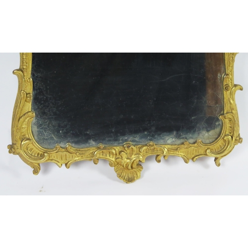 361 - A carved gilt wood wall mirror, the rectangular mirror plate enclosed by an arched frame with scroll... 