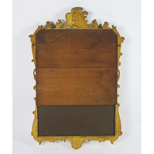 361 - A carved gilt wood wall mirror, the rectangular mirror plate enclosed by an arched frame with scroll... 