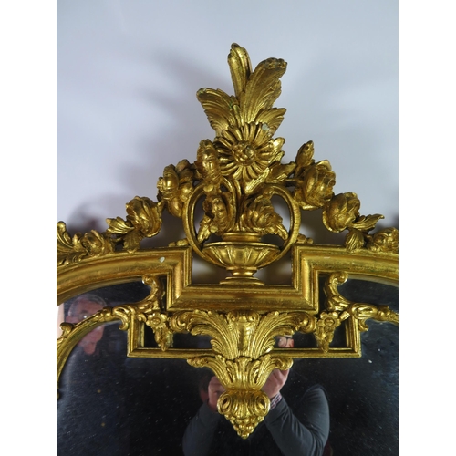 366 - A Louis XV style gilt wood pier glass of arched outline surmounted by a vase for flowers and foliage... 