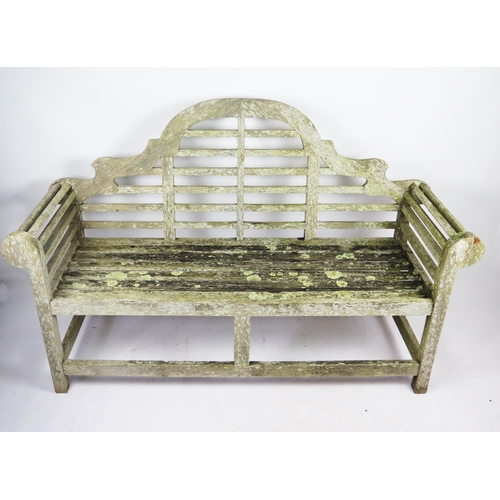 368 - A Lutyens style teak garden seat, with arched rail back, scroll ends, and railed seat, 165cm wide, 5... 