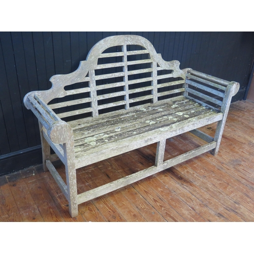 368 - A Lutyens style teak garden seat, with arched rail back, scroll ends, and railed seat, 165cm wide, 5... 