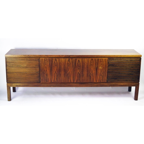 **WITHDRAWN FOR FUTURE SALE ONCE CITES HAS BEEN RECIEVED, APOLOGIES FOR THE INCONENIENCE** A modernist rosewood sideboard of rectangular outline, containing a pair of plain field central cupboard doors, flanked by a pair of louvered doors, raised in square  legs, 214cm wide, 46cm deep, 77cm high.
All lots to be cleared from the auction room by Tuesday 2nd April otherwise storage charges will apply - NO EXCEPTIONS.