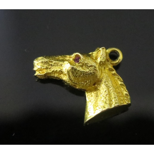 101 - A 9ct Gold and Ruby Horse Head Charm, hallmarked, 2.64g