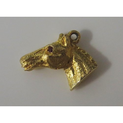 101 - A 9ct Gold and Ruby Horse Head Charm, hallmarked, 2.64g