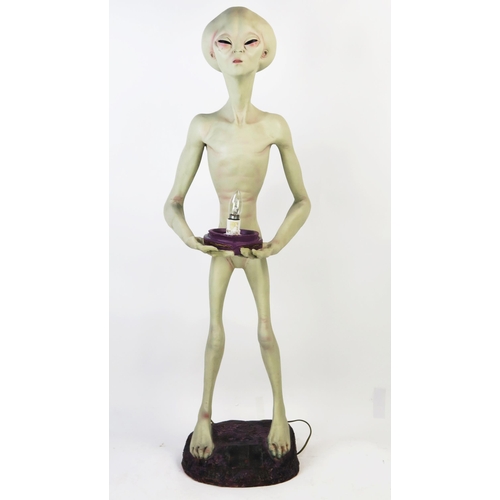 1033 - Life Size Alien Resin Figure holding a lamp (wired and working) standing on a purple rock base, 49.5... 