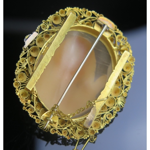 105 - A Shell Cameo Brooch in a precious yellow metal filigree setting, decorated with the bust of Hercule... 