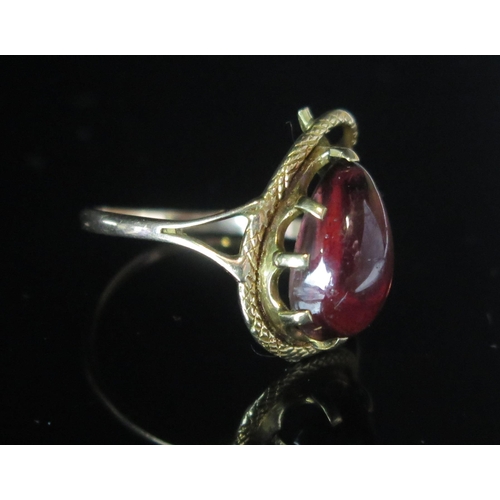 107 - An Antique 9ct Gold Snake Ring mounted with a cabochon garnet, 19.7x12.3mm head, size R.25, stamped ... 