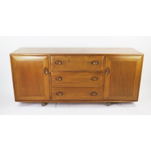 1138 - An Ercol Mid Elm Sideboard with three central drawers and cutlery tray flanked by a cupboard to each... 