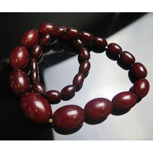 129 - A Faux Red Amber Graduated Bead Necklace, c. 29.5x20.9mm largest bead, 19