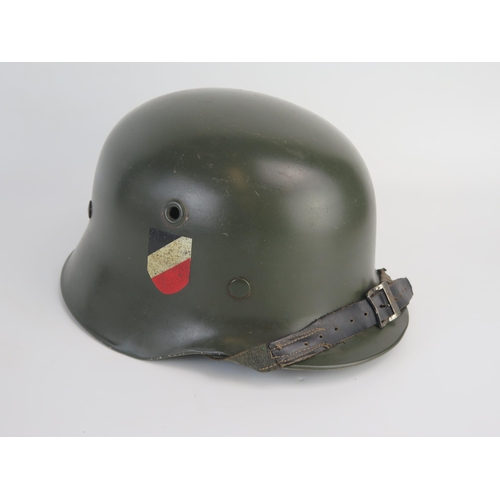 1549 - A World War II Wehrmacht model 1935 lightweight helmet, with transfers, leather liner and chin strap... 