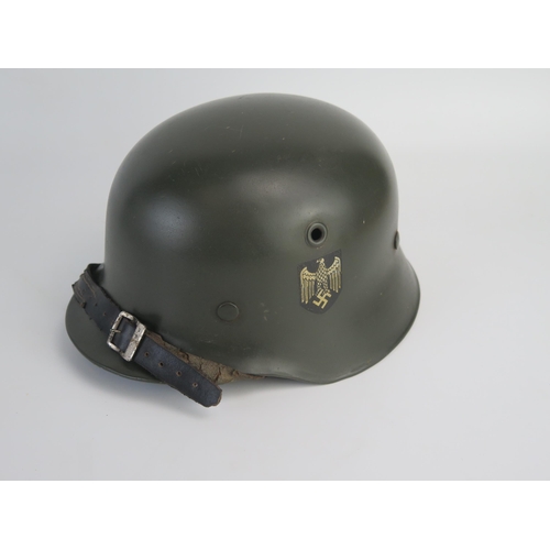 1549 - A World War II Wehrmacht model 1935 lightweight helmet, with transfers, leather liner and chin strap... 