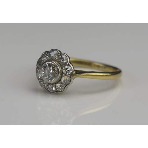 173 - An 18ct Gold and Diamond Cluster Ring, c. 3.9mm old cut principal stoner in a rub over setting, 10mm... 