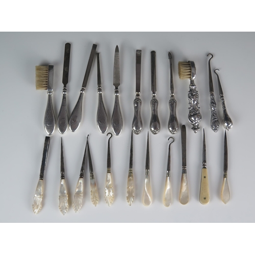 551 - A collection of silver handled and mother-of-pearl handled manicure items, nail files, button hooks,... 