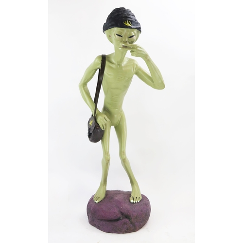 1034 - Life Size Alien Resin Figure with shoulder bag and hat decorated with yellow hemp, figures held to m... 