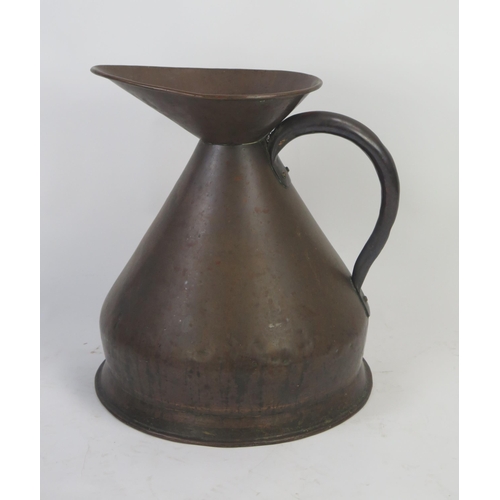 1294 - A large copper measure of traditional design, with loop handle 50cm high.