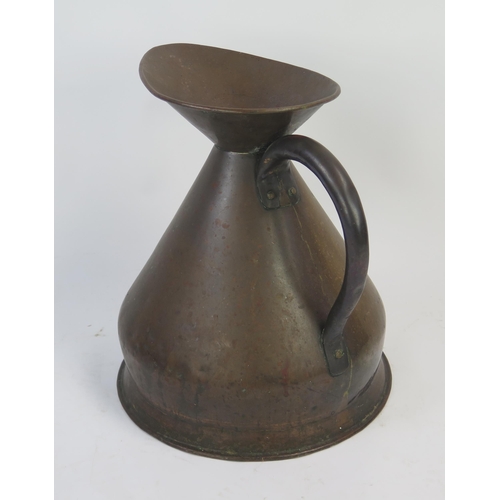 1294 - A large copper measure of traditional design, with loop handle 50cm high.