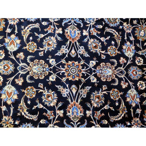 1686 - A Kashan carpet, the indigo field with all over trailing foliage, enclosed by a triple meander borde... 