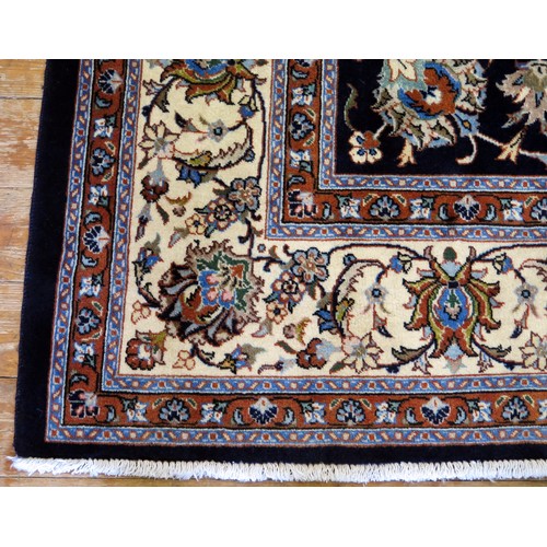 1686 - A Kashan carpet, the indigo field with all over trailing foliage, enclosed by a triple meander borde... 