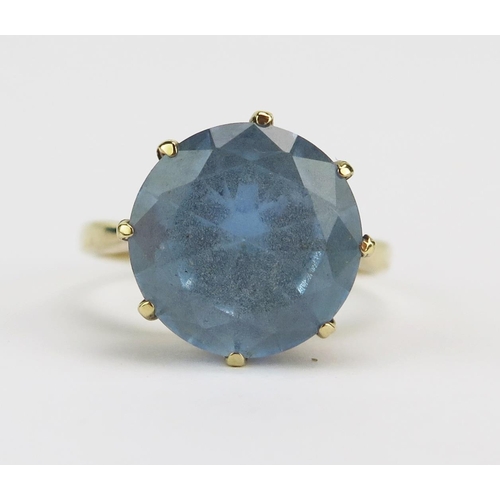 10 - A Blue Topaz Solitaire Dress Ring in a precious yellow metal setting, 11.3mm stone, size K.5, unmark... 