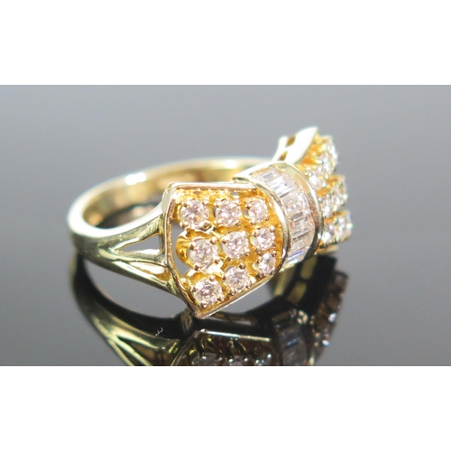 103 - An 18K Gold and Diamond Bow Ring, set with .93cts of brilliant round and baguette cut stones, size L... 