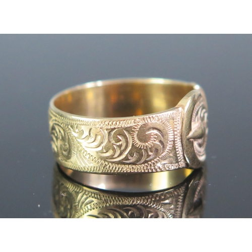 110 - A 9ct Gold Buckle Ring with chased foliate scroll decoration, 11.4mm wide buckle, size U.5, stamped ... 