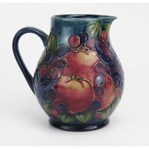 1121 - A contemporary Moorcroft pottery jug in the Finches and Fruit pattern, of bulbous form, with printed... 