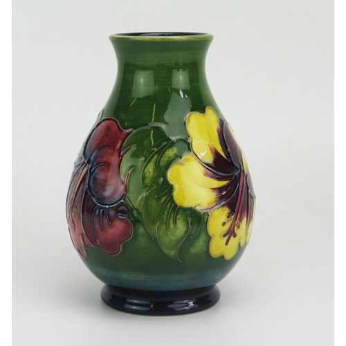 1122 - A contemporary Moorcroft pottery vase, with Hibiscus pattern decoration, of ovoid form, 14cm high.