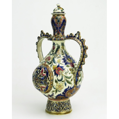 1128 - A Zsolnay Pecs twin-handled vase and cover, of ovoid outline, with domed cover, swept handles, the b... 