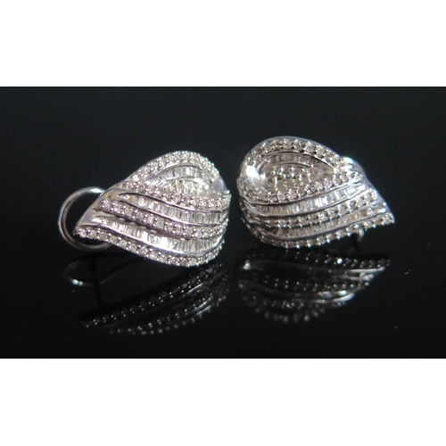 117 - A Pair of 9ct White Gold and Diamond Earrings set with brilliant round and baguette cuts, 19.7x13.5m... 