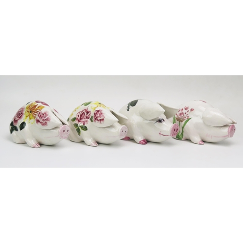 1172 - A group of four Exon Wemyss style pottery pigs, with painted floral decoration, one impressed PA, an... 