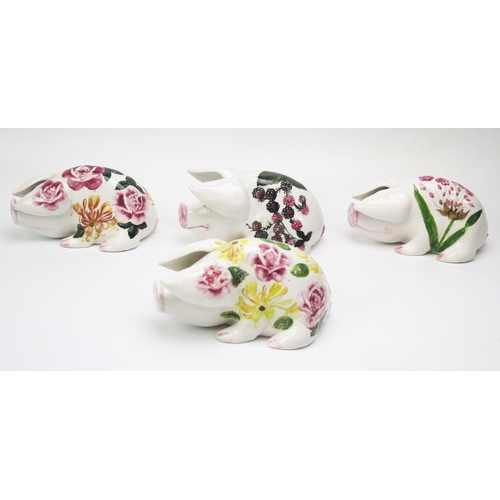 1172 - A group of four Exon Wemyss style pottery pigs, with painted floral decoration, one impressed PA, an... 