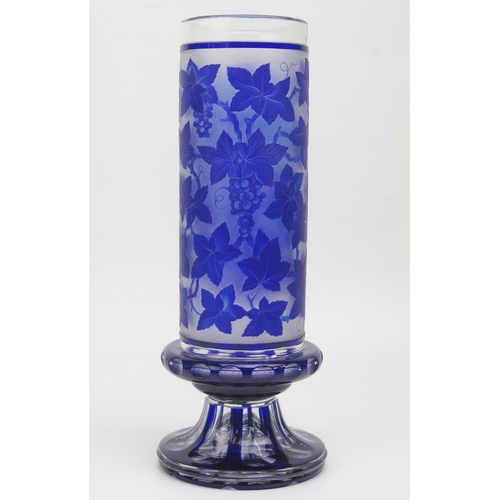 1184 - A Bohemian overlay blue glass vase, of cylindrical form, the central panel depicting drinking cavali... 