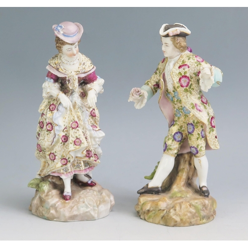 1191 - A pair of continental porcelain figures of a gallant and lady, in floral decorated garments on natur... 