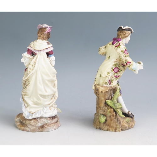 1191 - A pair of continental porcelain figures of a gallant and lady, in floral decorated garments on natur... 