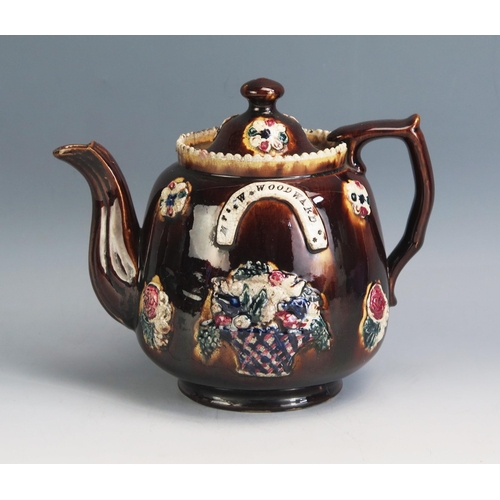 1195 - A Victorian barge ware teapot, with applied floral decoration to a treacle brown ground impressed Mr... 