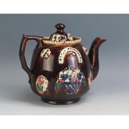 1195 - A Victorian barge ware teapot, with applied floral decoration to a treacle brown ground impressed Mr... 