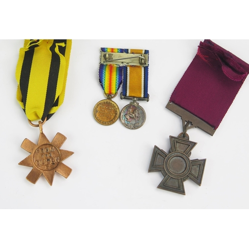 1215 - A replica Victoria Cross, replica Ashanti Star, and a miniature pair of World War One Medals.