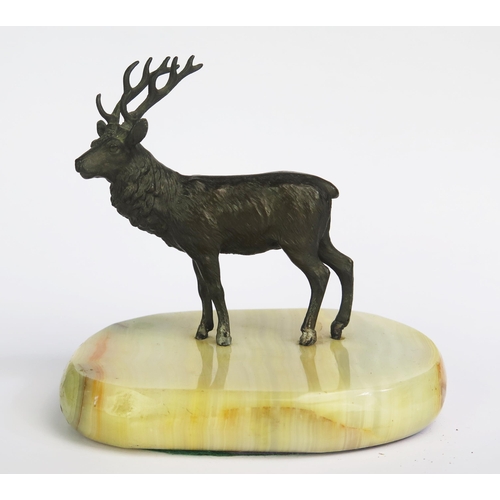 1315 - A bronzed metal study of a stag, mounted on a polished onyx base, 13cm wide.