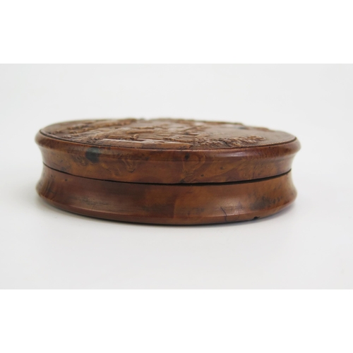 1317 - A 19th century pressed maple snuff box, of circular form the lid decorated with a riverside village ... 